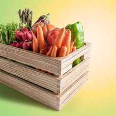 Świeże warzywa i owoce – oferta dla gastronomii Drewniana skrzynka wypełniona świeżymi warzywami: marchewką, rzodkiewką, sałatą i papryką, stanowiąca ofertę hurtowni warzyw i owoców Cytromax.